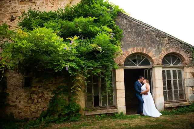 Couple de mariés dans une porte en pierre du Domaine de la Briouse