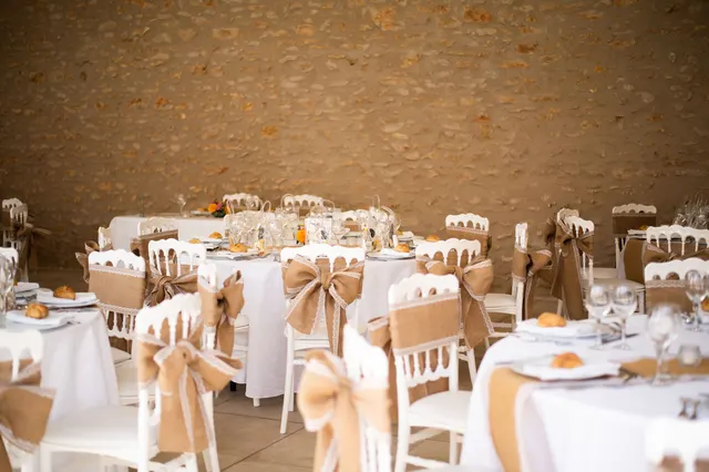 Tables dressées dans la salle Rigoletto, murs en pierre apparente